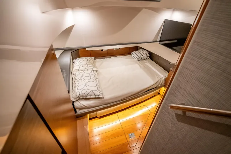 Slide: The Image of Cozy cabin interior of 2019 Tiara Yachts 38 LS with modern bedding and warm lighting. - 33