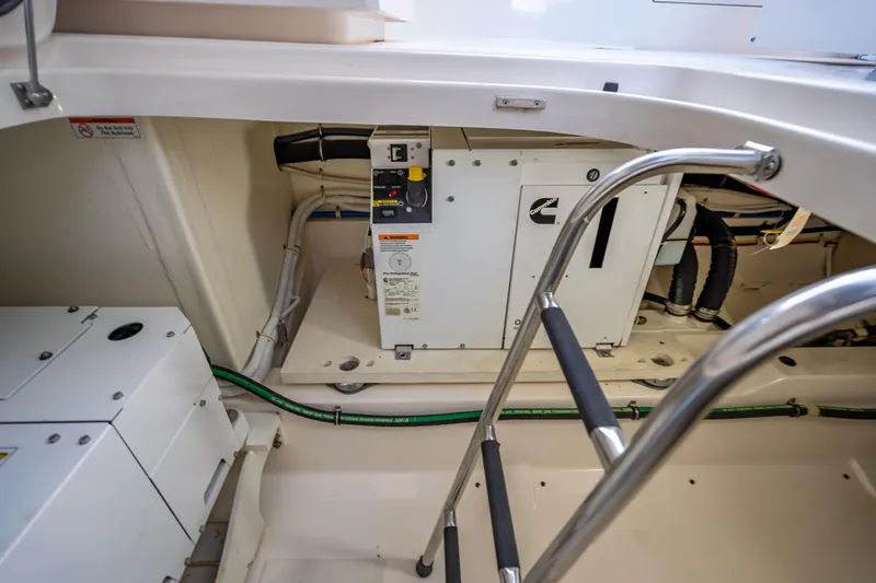 Slide: The Image of Engine compartment of 2019 Tiara Yachts 38 LS, featuring Cummins generator and access ladder. - 40