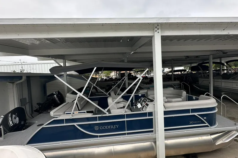The Image of 2026 Sweetwater EX 2286 SFLX pontoon boat under covered storage. - 1