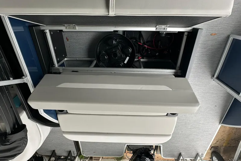 Slide: The Image of 2026 Sweetwater EX 2286 SFLX boat interior with open storage compartment and visible steering wheel. - 14