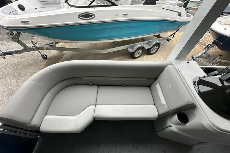 Slide: The Image of 2026 Sweetwater EX 2286 SFLX boat interior with gray seating and cup holder. - 16
