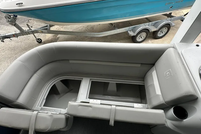 Slide: The Image of 2026 Sweetwater EX 2286 SFLX boat interior with storage compartment, gray seating, and cup holder. - 17