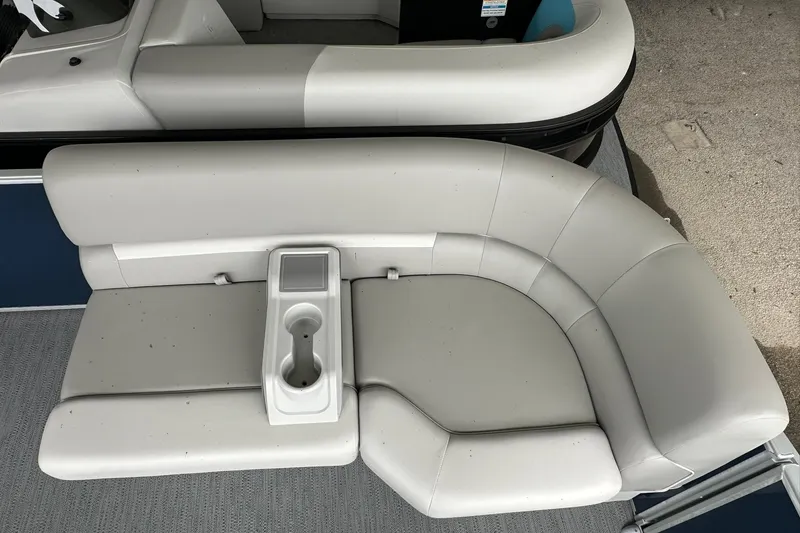 Slide: The Image of 2026 Sweetwater EX 2286 SFLX boat seating with cup holder, featuring white upholstery. - 18