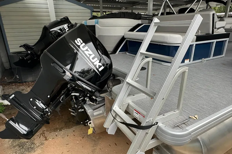 Slide: The Image of 2026 Sweetwater EX 2286 SFLX pontoon boat with Suzuki outboard motor and boarding ladder. - 21