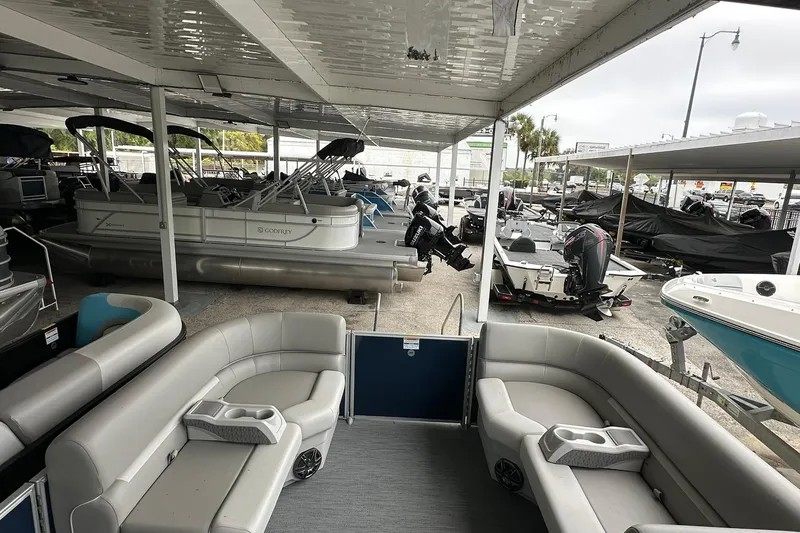 Slide: The Image of 2026 Sweetwater EX 2286 SFLX pontoon boat interior at a marina showroom. - 6