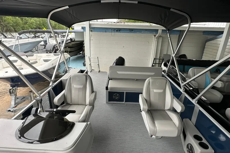 Slide: The Image of 2026 Sweetwater EX 2286 SFLX pontoon boat interior with seating and helm under canopy. - 7