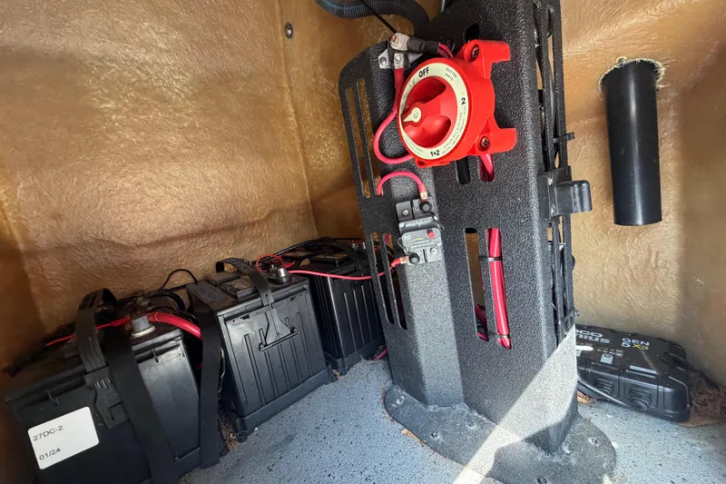 Slide: The Image of 2024 Xpress H190B Bay boat battery compartment with wiring and switch panel. - 10