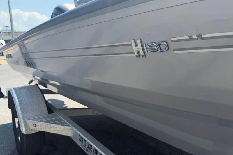 Slide: The Image of 2024 Xpress H190B Bay boat on trailer, side view with logo detail. - 2