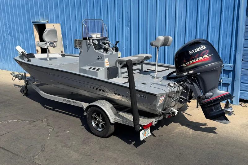 Slide: The Image of 2024 Xpress H190B Bay boat with Yamaha engine, parked by a blue building. - 5