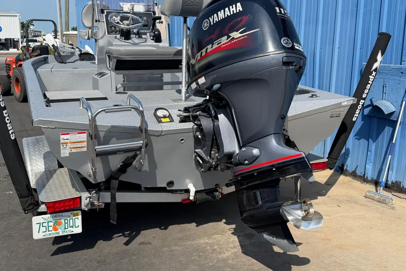 Slide: The Image of 2024 Xpress H190B Bay boat with Yamaha outboard motor, parked near blue building. - 6