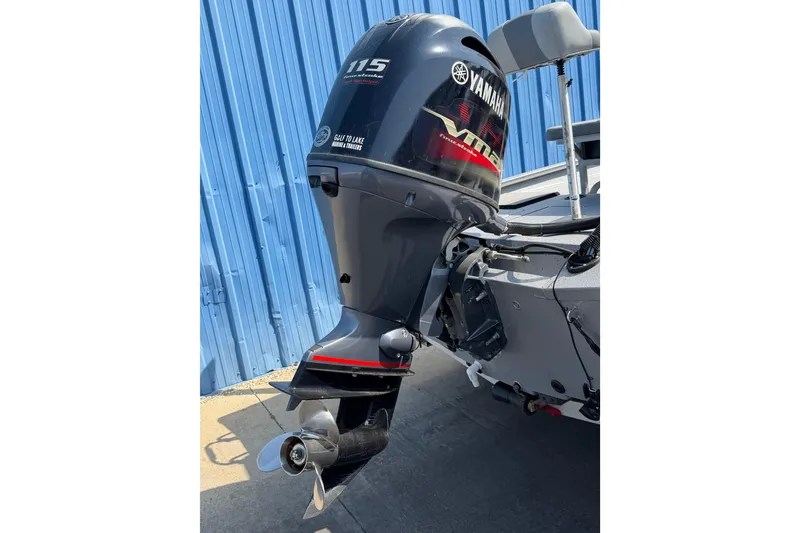 Slide: The Image of 2024 Xpress H190B Bay boat with Yamaha 115 outboard motor, parked by blue wall. - 7