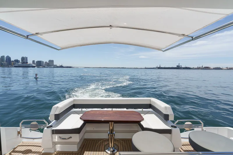 Slide: The Image of The image shows the stern of a 2019 Cruisers 50 Cantius yacht overlooking the water. - 46
