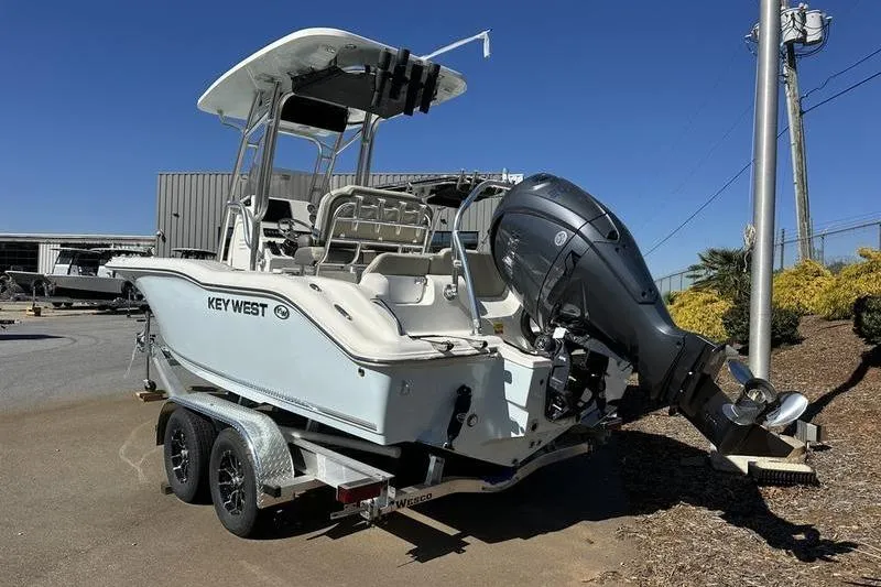 The Image of 2026 Key West 219 FS boat on trailer, featuring outboard motor, parked outdoors. - 0