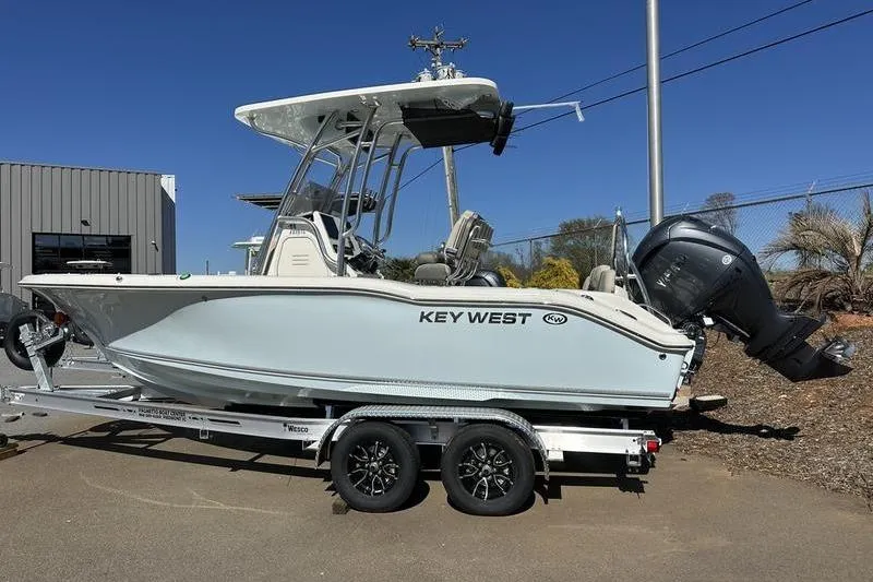 Slide: The Image of 2026 Key West 219 FS boat on trailer, parked outdoors, side view. - 2