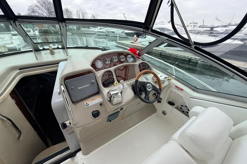 Slide: The Image of 2007 Sea Ray Sundancer 320 helm with steering wheel, gauges, and Raymarine navigation system. - 11