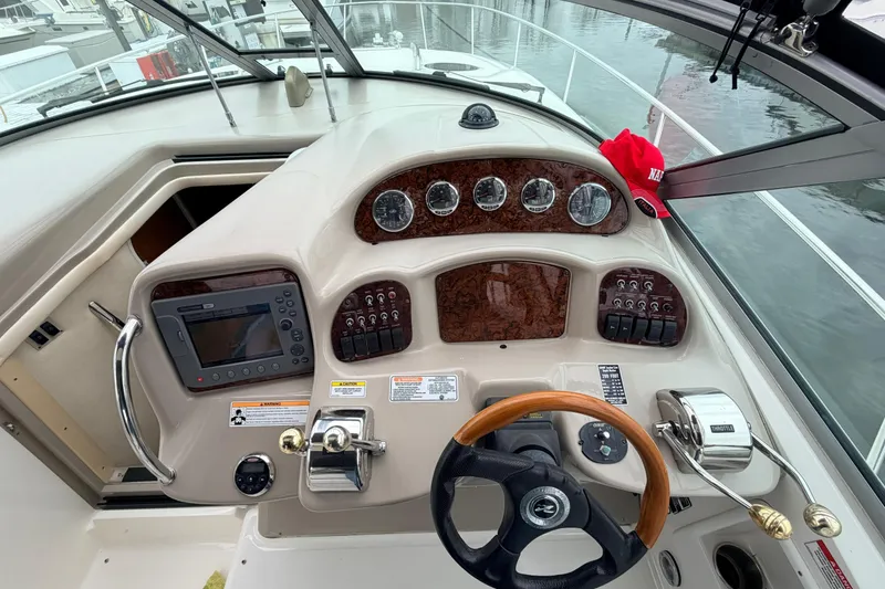 Slide: The Image of 2007 Sea Ray Sundancer 320 helm with gauges, controls, and a red cap on the dashboard. - 12