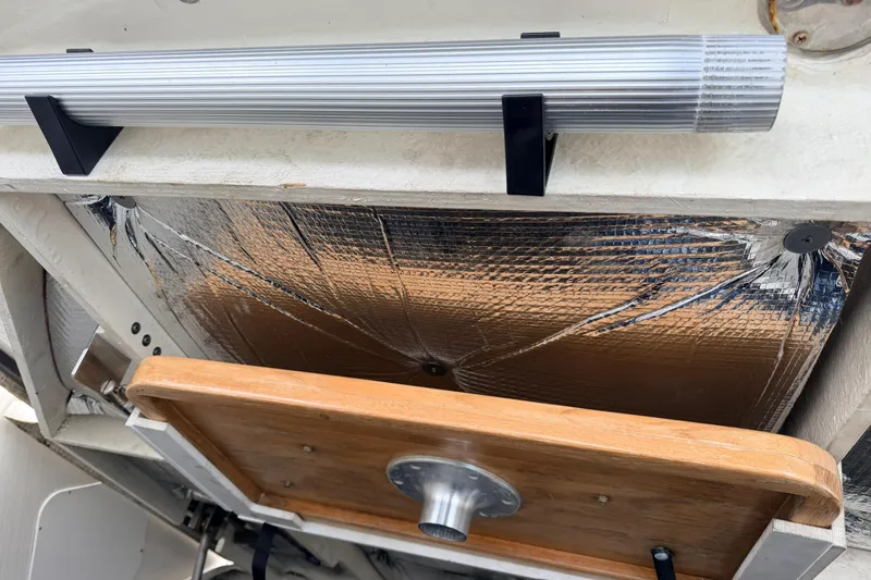 Slide: The Image of 2007 Sea Ray Sundancer 320 boat interior with reflective insulation and wooden table detail. - 25