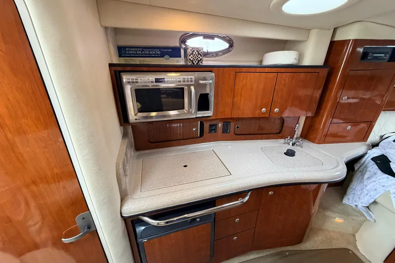 Slide: The Image of Luxurious 2007 Sea Ray Sundancer 320 yacht interior with kitchenette and wood cabinetry. - 32