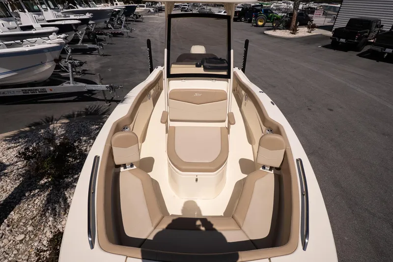 Slide: The Image of 2026 Scout 215 XSF boat interior with beige seating, parked in a marina. - 15