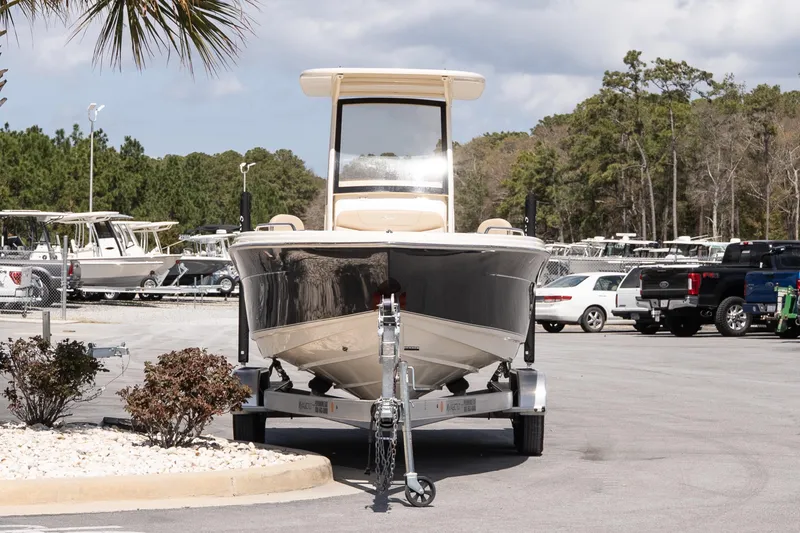 Slide: The Image of 2026 Scout 215 XSF boat on trailer in parking lot, surrounded by trees and vehicles. - 3