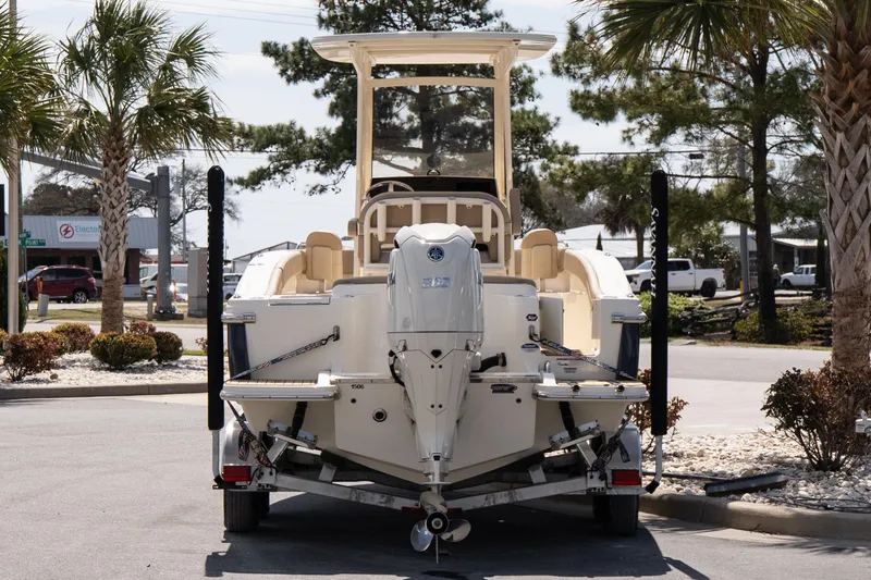 Slide: The Image of 2026 Scout 215 XSF boat on trailer, parked outdoors with palm trees nearby. - 5