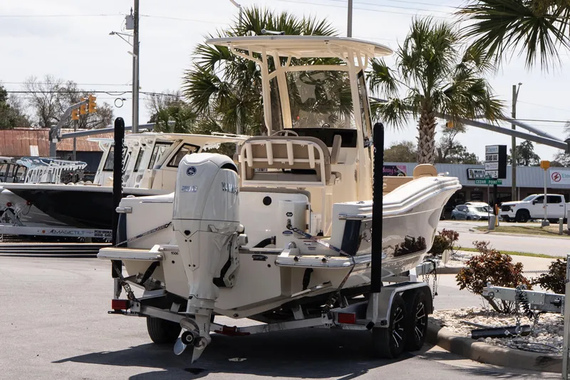 Slide: The Image of 2026 Scout 215 XSF boat on trailer, parked outdoors near palm trees. - 6