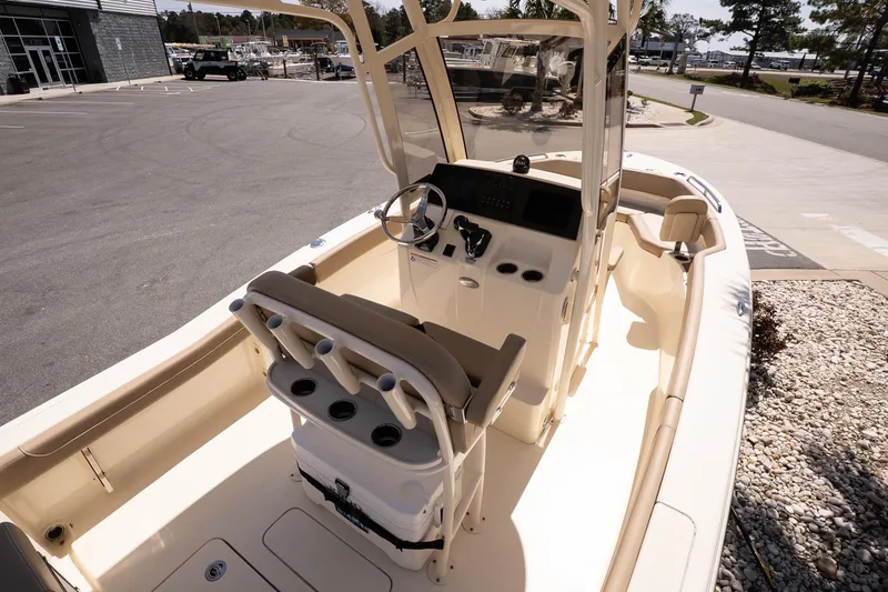 Slide: The Image of 2026 Scout 215 XSF boat interior with helm, seating, and console in a marina setting. - 8
