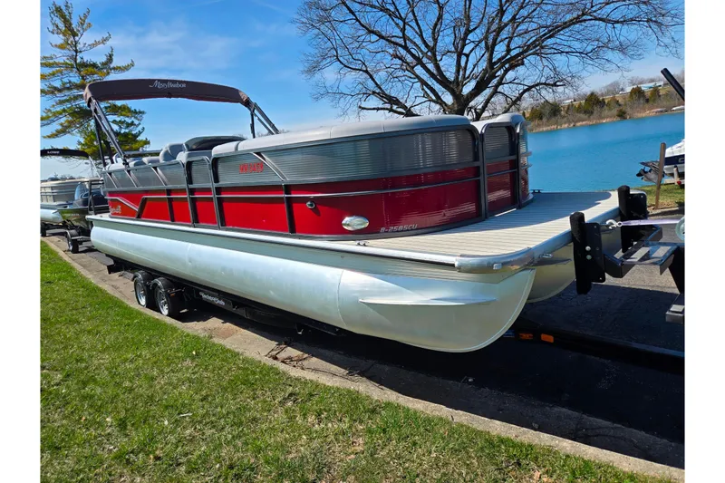 Slide: The Image of 2018 Misty Harbor 2585 Biscayne Bay CU pontoon boat on trailer by a lake. - 9