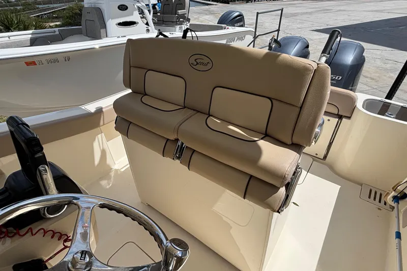 Slide: The Image of 2016 Scout 255 LXF boat interior with beige seating and steering wheel. - 10