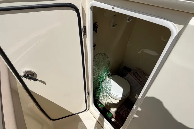 Slide: The Image of 2016 Scout 255 LXF boat interior with open storage compartment and toilet. - 14