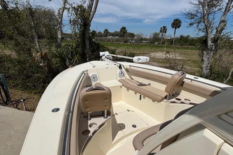 Slide: The Image of 2016 Scout 255 LXF boat interior with seating and speakers, surrounded by trees. - 20