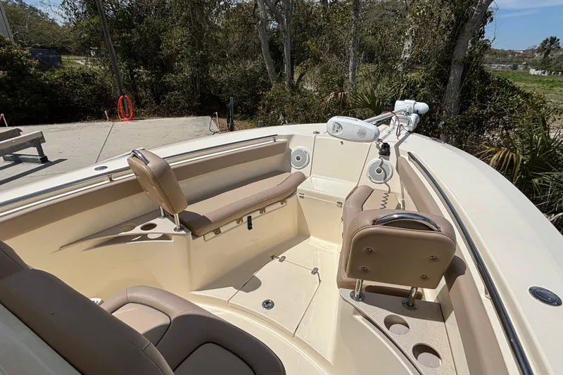 Slide: The Image of 2016 Scout 255 LXF boat interior with seating and speakers, docked outdoors. - 21