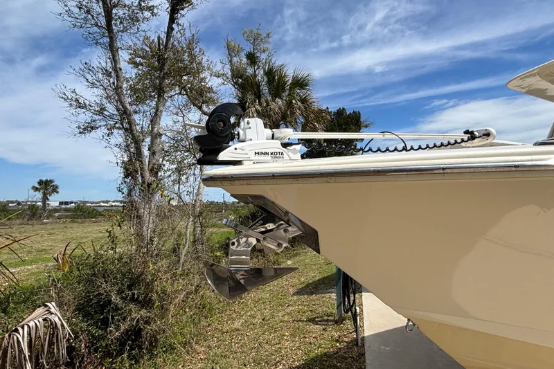 Slide: The Image of 2016 Scout 255 LXF boat with Minn Kota trolling motor, parked near trees. - 30