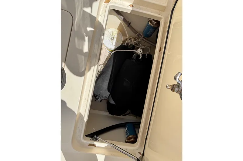 Slide: The Image of Storage compartment of a 2016 Scout 255 LXF boat with various items inside. - 4