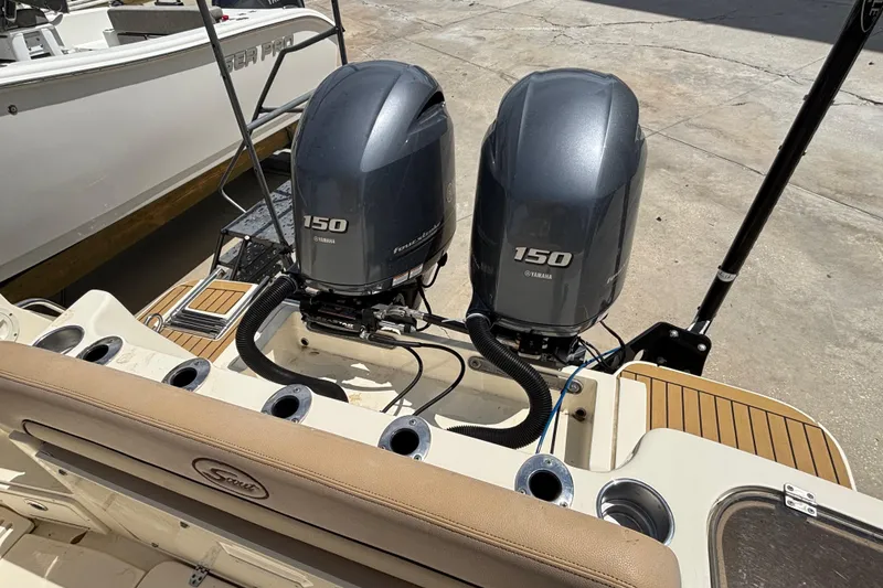 Slide: The Image of 2016 Scout 255 LXF boat with twin Yamaha 150 engines, docked outdoors. - 7