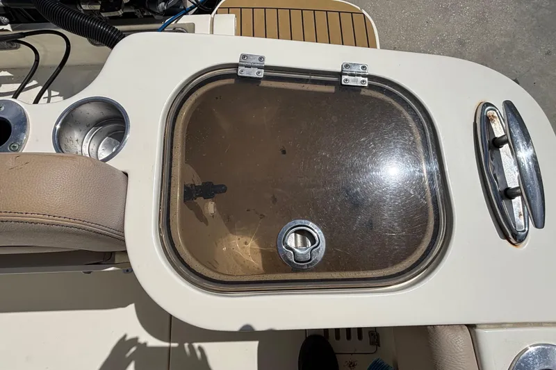 Slide: The Image of Livewell compartment on a 2016 Scout 255 LXF boat, featuring cup holders and seating. - 8