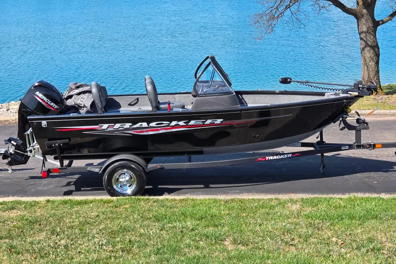 The Image of 2024 Tracker Pro Guide V-16 WT boat on trailer by a lake. - 0
