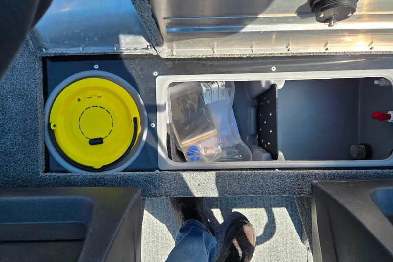 Slide: The Image of 2024 Tracker Pro Guide V-16 WT boat storage compartments with yellow bucket and gear. - 17