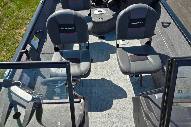Slide: The Image of 2024 Tracker Pro Guide V-16 WT boat interior with two gray seats and steering console. - 22