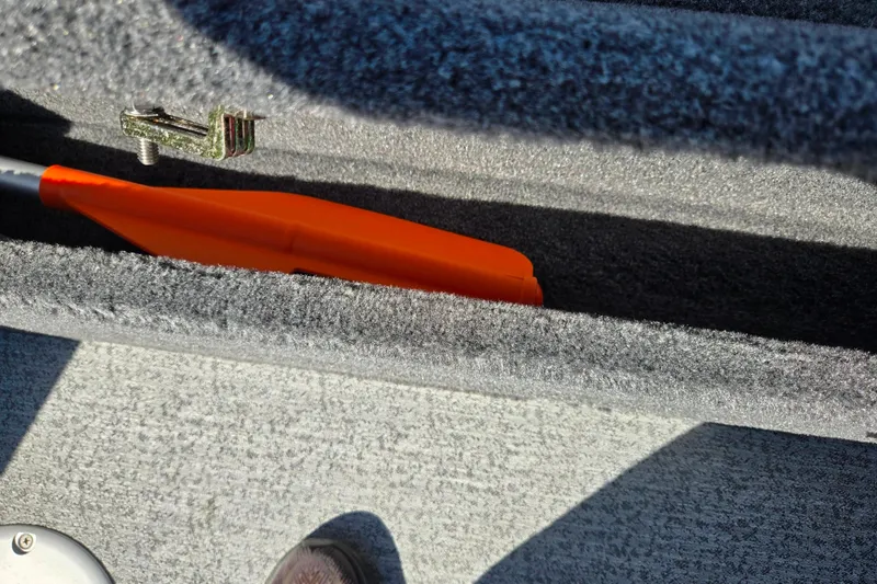 Slide: The Image of Storage compartment with orange paddle in 2024 Tracker Pro Guide V-16 WT boat. - 23