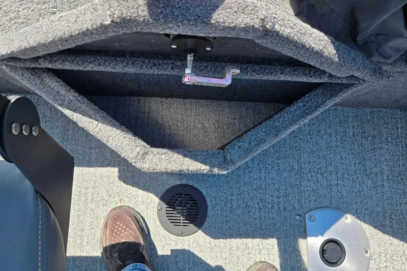 Slide: The Image of 2024 Tracker Pro Guide V-16 WT boat interior with carpeted storage compartment and footrest. - 25