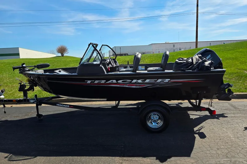 Slide: The Image of 2024 Tracker Pro Guide V-16 WT boat on trailer, parked outdoors. - 4