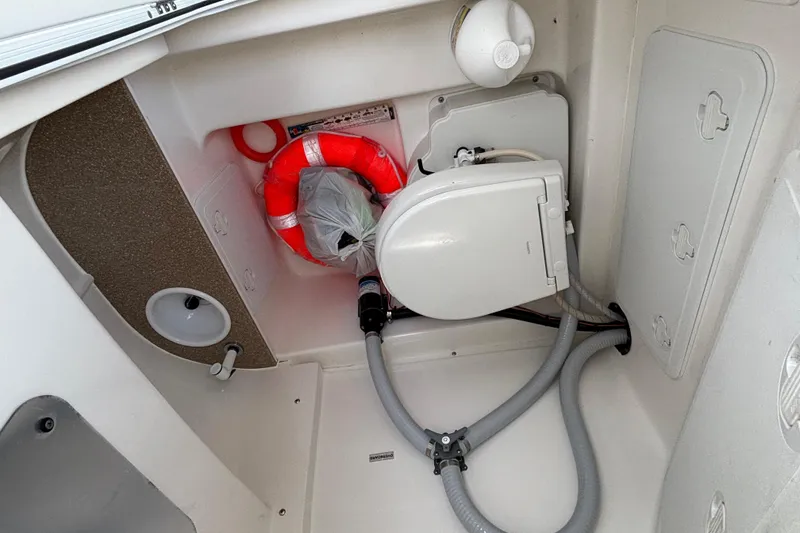 Slide: The Image of Interior of 2023 Sea Pro 239 Deep V CC boat with marine toilet and safety equipment. - 2