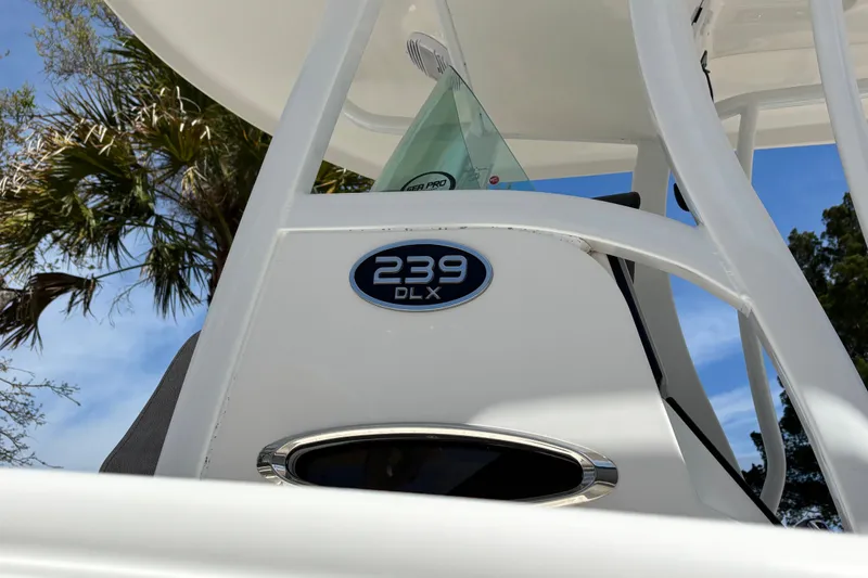Slide: The Image of 2023 Sea Pro 239 Deep V CC boat detail with logo, against a clear sky backdrop. - 25