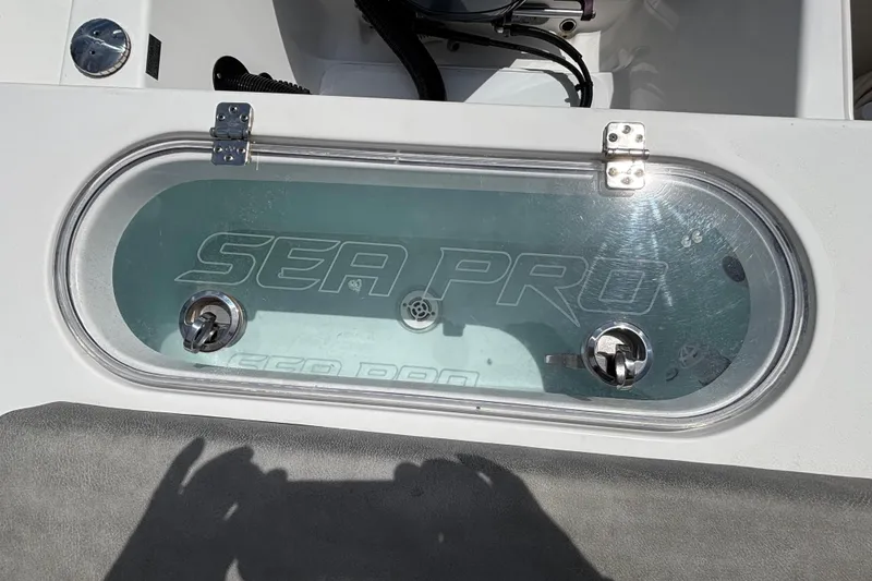 Slide: The Image of Livewell on 2023 Sea Pro 239 Deep V CC boat, featuring clear lid and secure latches. - 6