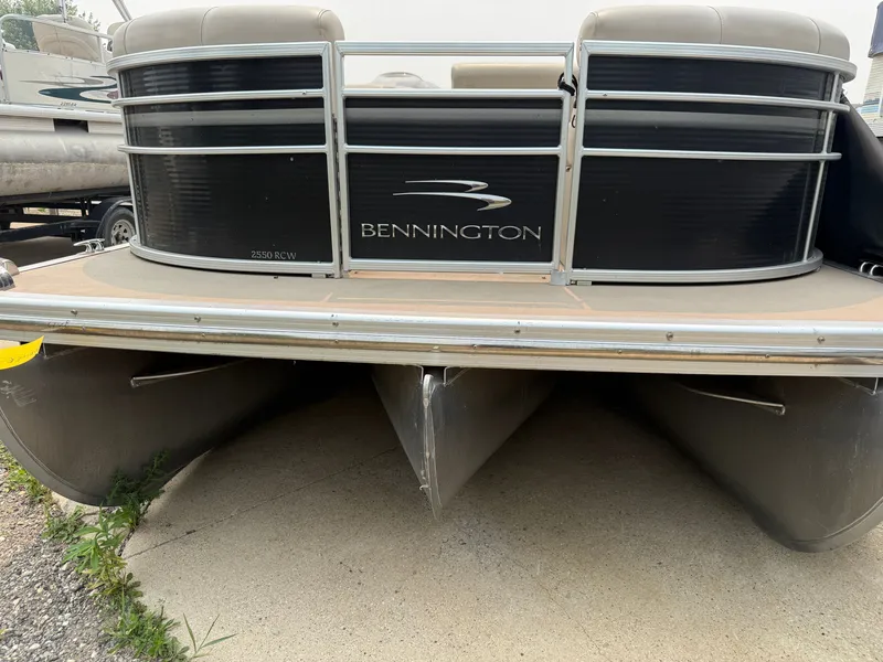 Slide: The Image of A 2010 Bennington 2550 RCW pontoon boat with a black hull and silver details. - 1