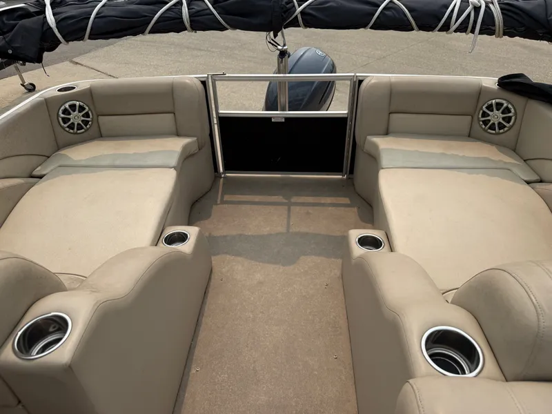 Slide: The Image of The image shows the spacious cockpit of a 2010 Bennington 2550 RCW with beige seating and cup holders. - 14