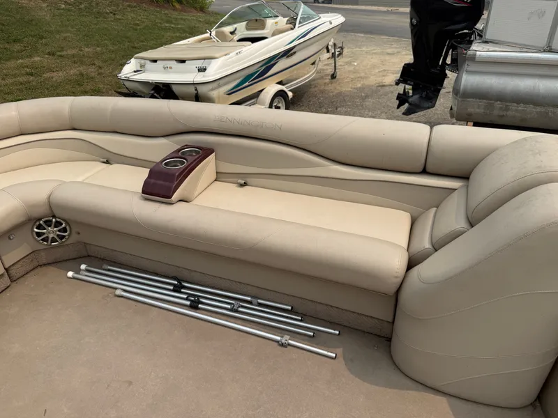 Slide: The Image of The image shows the beige seating area of a 2010 Bennington 2550 RCW with cup holders. - 12