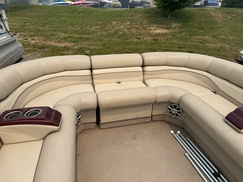 Slide: The Image of The image shows beige seating on a 2010 Bennington 2550 RCW with cup holders. - 13