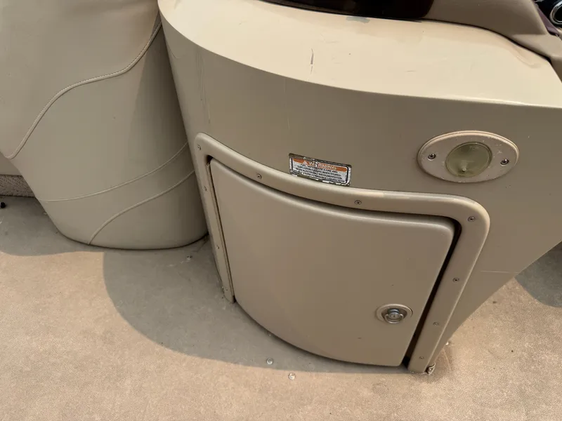 Slide: The Image of Close-up of a beige boat console area with a small door and a round light. - 18